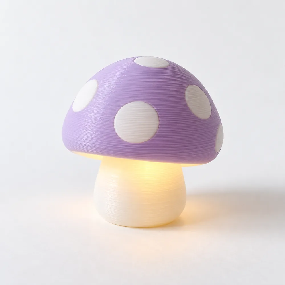 Svampnattlampan, en lampa formad som en svamp med lila prickig hatt och vit fot som lyser varmt